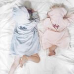Two small children in bathrobes with names on the back