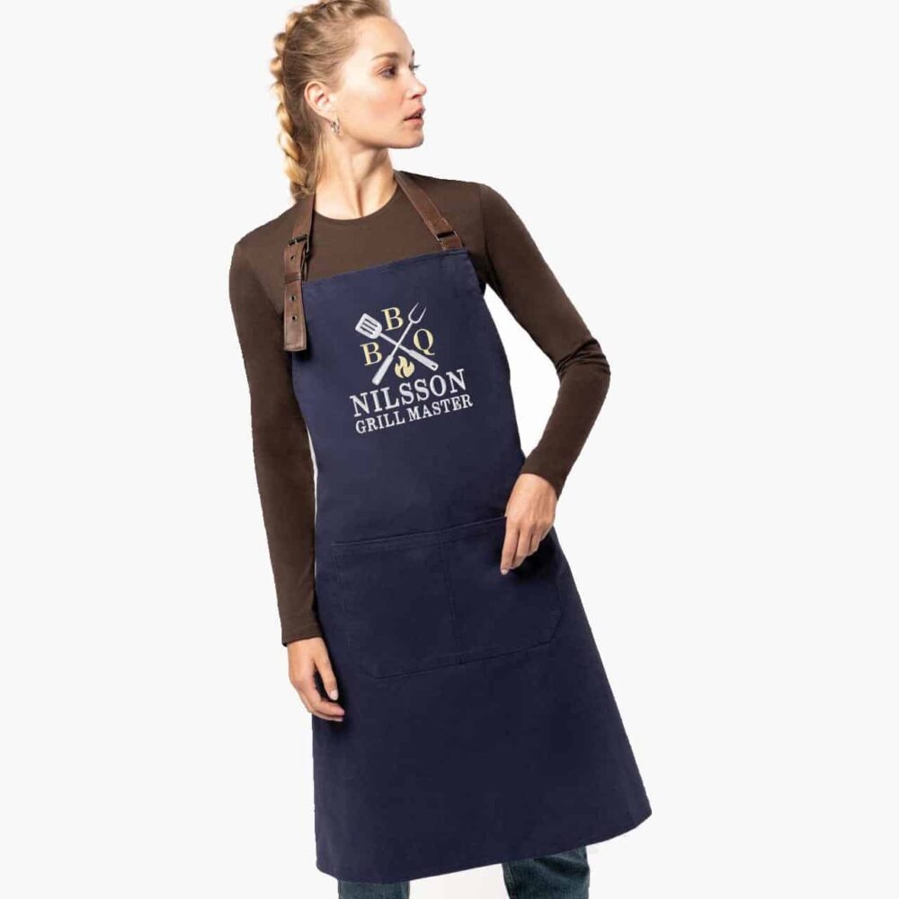 Woman wearing a personalized navy blue apron with embroidered name